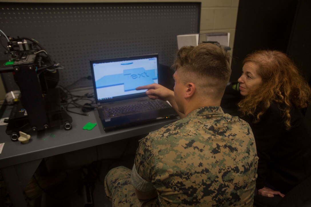 A Marine shows a member from the Defense Advanced Research Projects Agency how he uses a 3-D printer at the additive manufacturing facility at Camp Lejeune, N.C., March 22, 2017. Nine members with the Defense Advanced Research Projects Agency visited the facility to learn more about how technology is benefitting the Marine Corps. The Marines are with 2nd Maintenance Battalion, Combat Logistics Regiment 25, 2nd Marine Logistics Group. (U.S. Marine Corps photo by Pfc. Abrey Liggins)