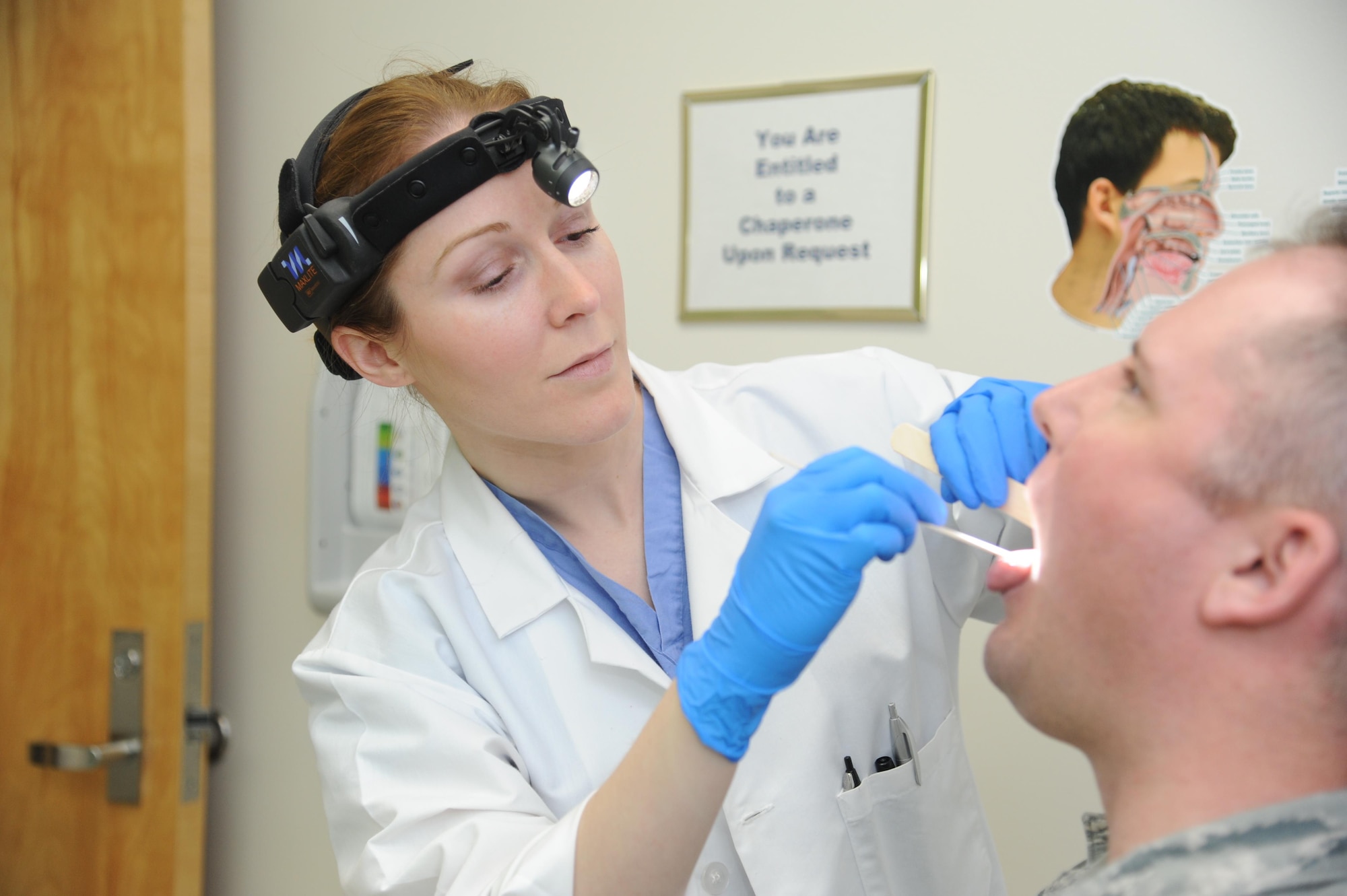 U.S. Air Force Major (Dr.) Whitney Pafford, 88th Surgical Operations Squadron Ear, Nose and Throat Medical Director at Wright-Patterson Medical Center’s Department of Otolaryngology, checks a patient for irregularities or signs of cancer at Wright-Patterson Air Force Base, Ohio, March 17. Dr. Pafford has served patients as a military doctor for four years. (U.S. Air Force photo/Tech Sgt. Scott Johnson)