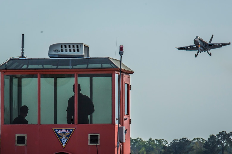 Landing signal officers communicate with a pilot preparing to land on a simulated aircraft carrier aboard Marine Corps Air Station Beaufort, March 22. The LSOs analyze the glide slope path and the movement of the carrier to decide whether the aircraft can land. The LSOs are with Marine Fighter Attack Squadron 312, Marine Aircraft Group 31.