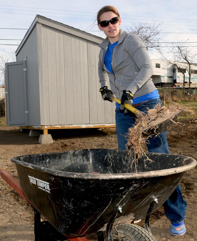 An Airman with the 89th Attack Squadron fills a wheel-barrel full of dirt during a Habitat for Humanity home build in Rapid City, S.D., March 18, 2017, as part of Women’s History Month. Nine women participated in the build help finish up a family’s home with work such as rock landscaping, grass seeding, and dirt work. (U.S. Air Force photo by Airman 1st Class Donald C. Knechtel)