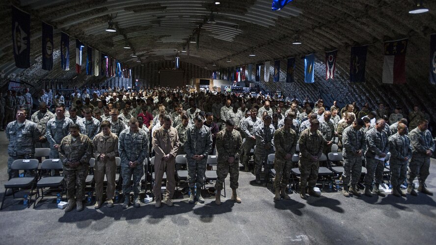 Airmen of the 332nd Air Expeditionary Wing bow their heads for an innvocation during a fallen warrior memorial ceremony Mar. 23, 2017, in Southwest Asia. The ceremony was held for Staff Sgt. Alexandria Morrow, 332nd Expeditionary Maintenance Group weapons load crew member, who died from injuries sustained while performing work duties in support of Operation Inherent Resolve. (U.S. Air Force photo by Staff Sgt. Eboni Reams)