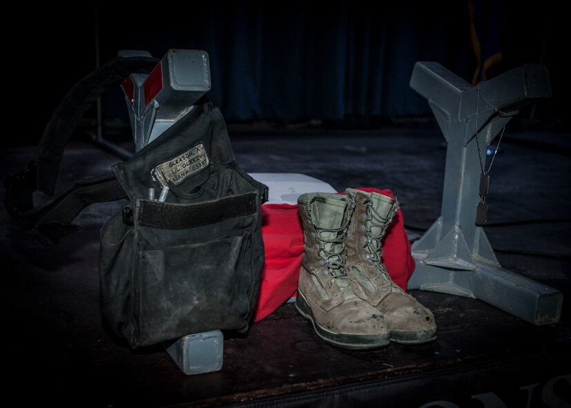 A munitions Y stand containing the weapons pouch, boots, and dog tags of Staff Sgt. Alexandria Morrow, 332nd Expeditionary Maintenance Squadron weapons load crew chief, is displayed during a fallen warrior memorial ceremony Mar. 23, 2017, in Southwest Asia. Morrow died from injuries sustained while performing work duties in support of Operation Inherent Resolve. (U.S. Air Force photo by Staff Sgt. Eboni Reams)