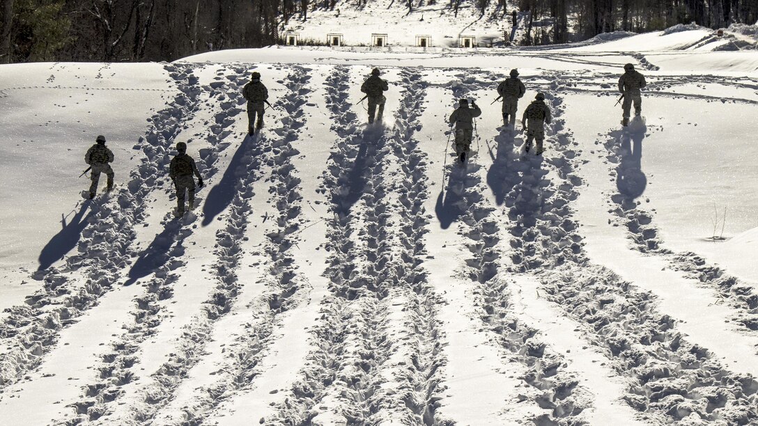 Soldiers advance through snow to their next firing position during a stress shoot as part of the Vermont Best Warrior Competition at Camp Ethan Allen Training Site, Jericho, Vt., March 18, 2017.  During the three-day event, elite soldiers take physical fitness tests and written exams, and perform warrior tasks relevant to the current environment.  Army National Guard Photo by 1st Lt. Benjamin Haulenbeek