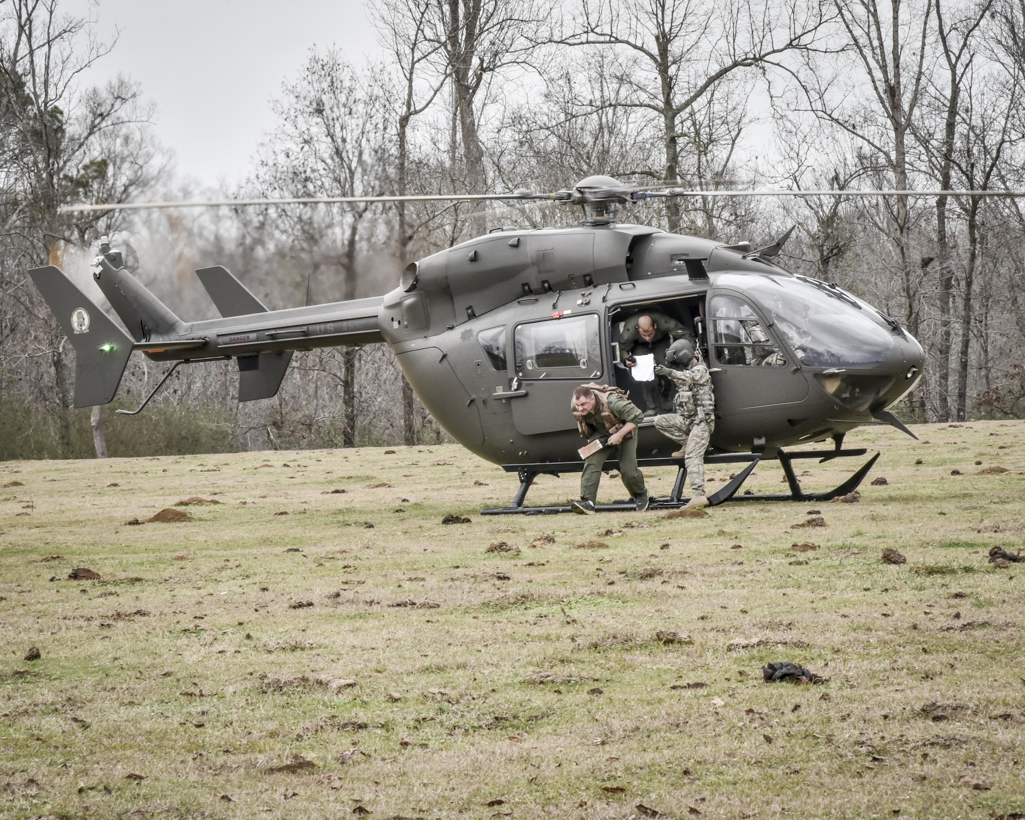 Aircrew from the 117th Air Refuelling Wing exit an Alabama Army National Guard helicopter during survival training in Hanceville, Alabama February 12, 2017. (U.S. Air National Guard photo by: Senior Master Sgt. Ken Johnson)