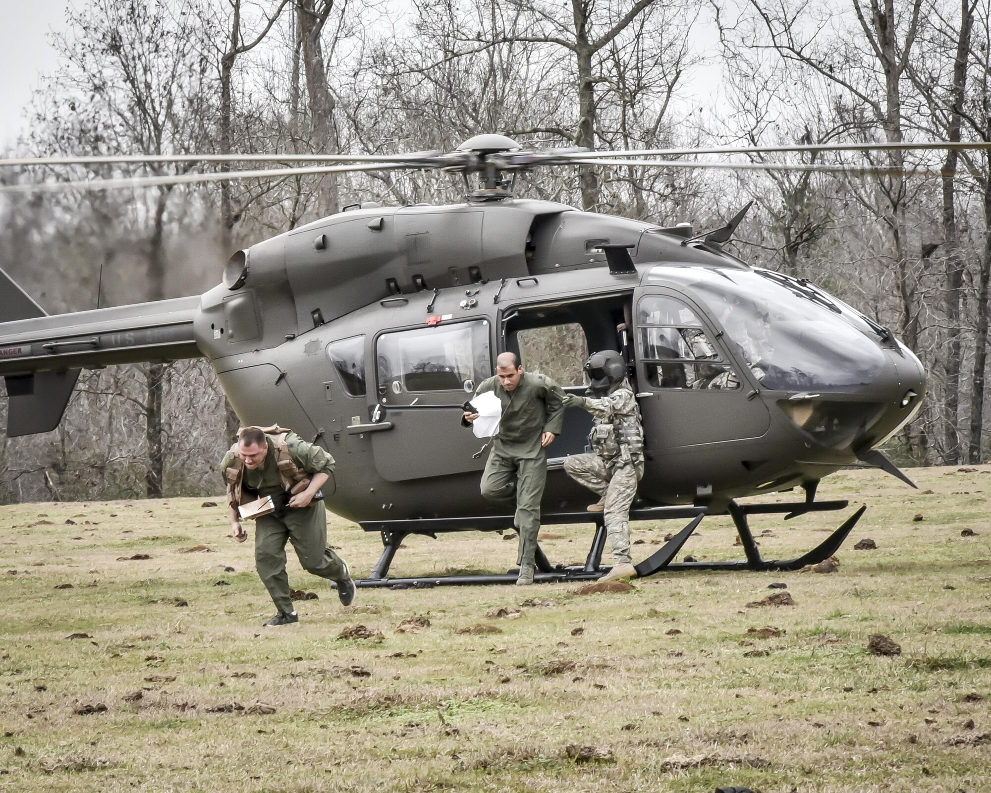 Aircrew from the 117th Air Refuelling Wing exit an Alabama Army National Guard helicopter during survival training in Hanceville, Alabama February 12, 2017. (U.S. Air National Guard photo by: Senior Master Sgt. Ken Johnson)