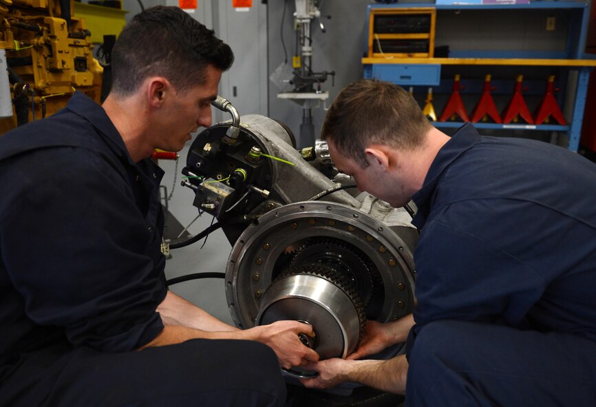 Airman 1st Class Justyn Zangwill (left), 627th Logistic Readiness Squadron fire truck and refuel maintenance journeyman and Senior Airman William Schlee (right), 627th LRS material handling equipment mechanic, install a wet clutch assembly, March 21, 2017 at Joint Base Lewis-McChord, Wash. The fire truck maintenance shop discovered an issue on a McChord fire truck and saved the Air Force thousands of dollars to repair it. (U.S. Air Force photo/Senior Airman Divine Cox)