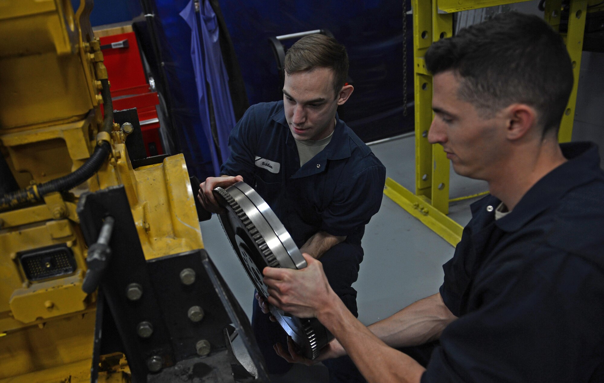 Senior Airman William Schlee (left), 627th Logistic Readiness Squadron material handling equipment mechanic and Airman 1st Class Justyn Zangwill (right), 627th LRS fire truck and refuel maintenance journeyman install a torsion coupler, March 21, 2017 at Joint Base Lewis-McChord, Wash. The torsion coupler, compresses everything together when the pumps are engaged, but the torsion reduces the shock on the springs. (U.S. Air Force photo/Senior Airman Divine Cox)