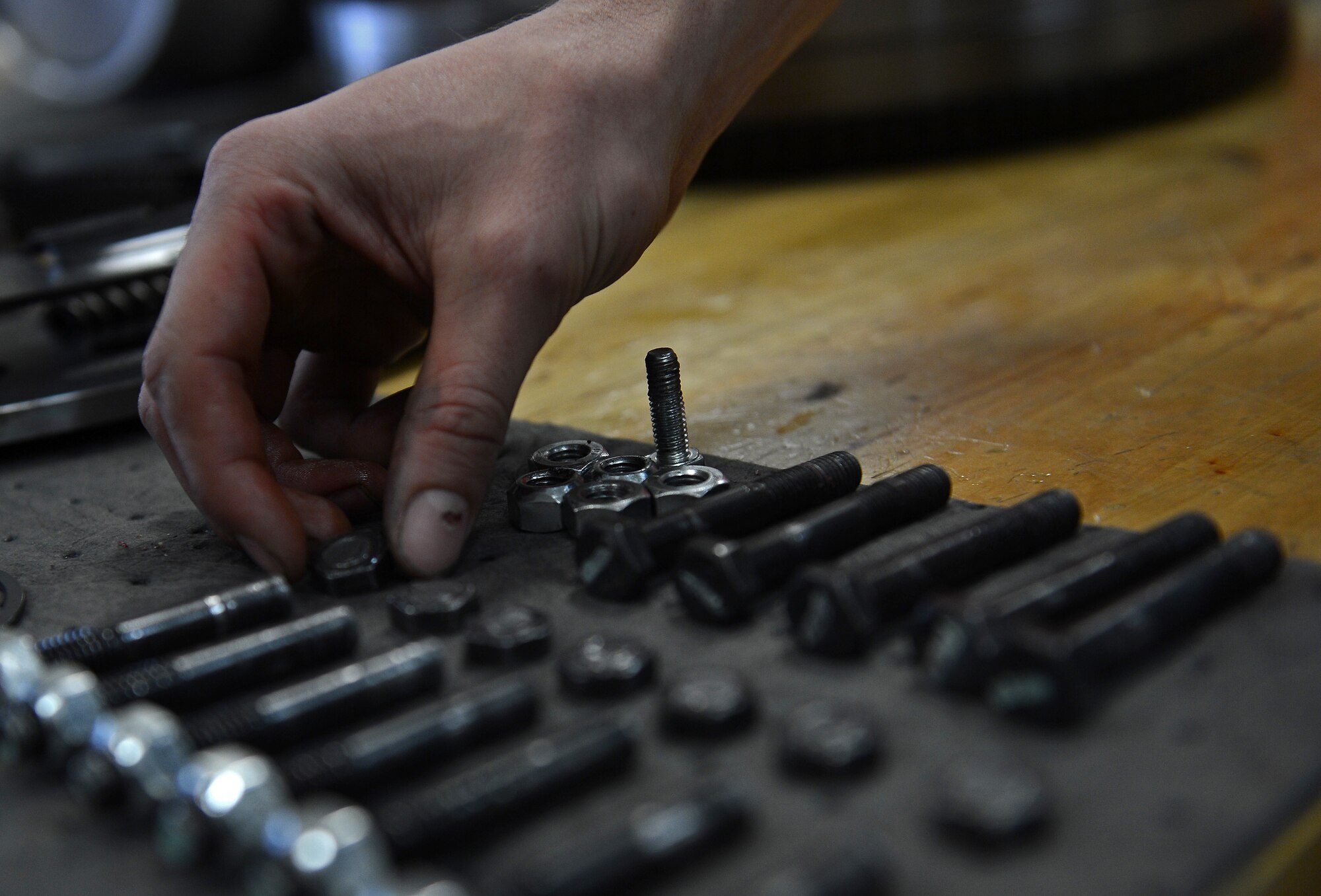 Airman 1st Class Justyn Zangwill, 627th Logistic Readiness Squadron fire truck and refuel maintenance journeyman, inspect broken bolts from a torsion coupler, March 21, 2017 at Joint Base Lewis-McChord, Wash. Zangwill had to remove the engine and the power divider assembly, to locate seven broken bolts and a broken spring inside the torsion coupler. (U.S. Air Force photo/Senior Airman Divine Cox)