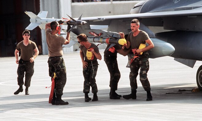 Ground crewmen remove the safety features from a pair of AIM-9 Sidewinder missiles on a 388th Tactical Fighter Wing F-16C Fighting Falcon aircraft about to depart for Saudi Arabia to take part in Operation Desert Shield. (U.S. Air Force photo)