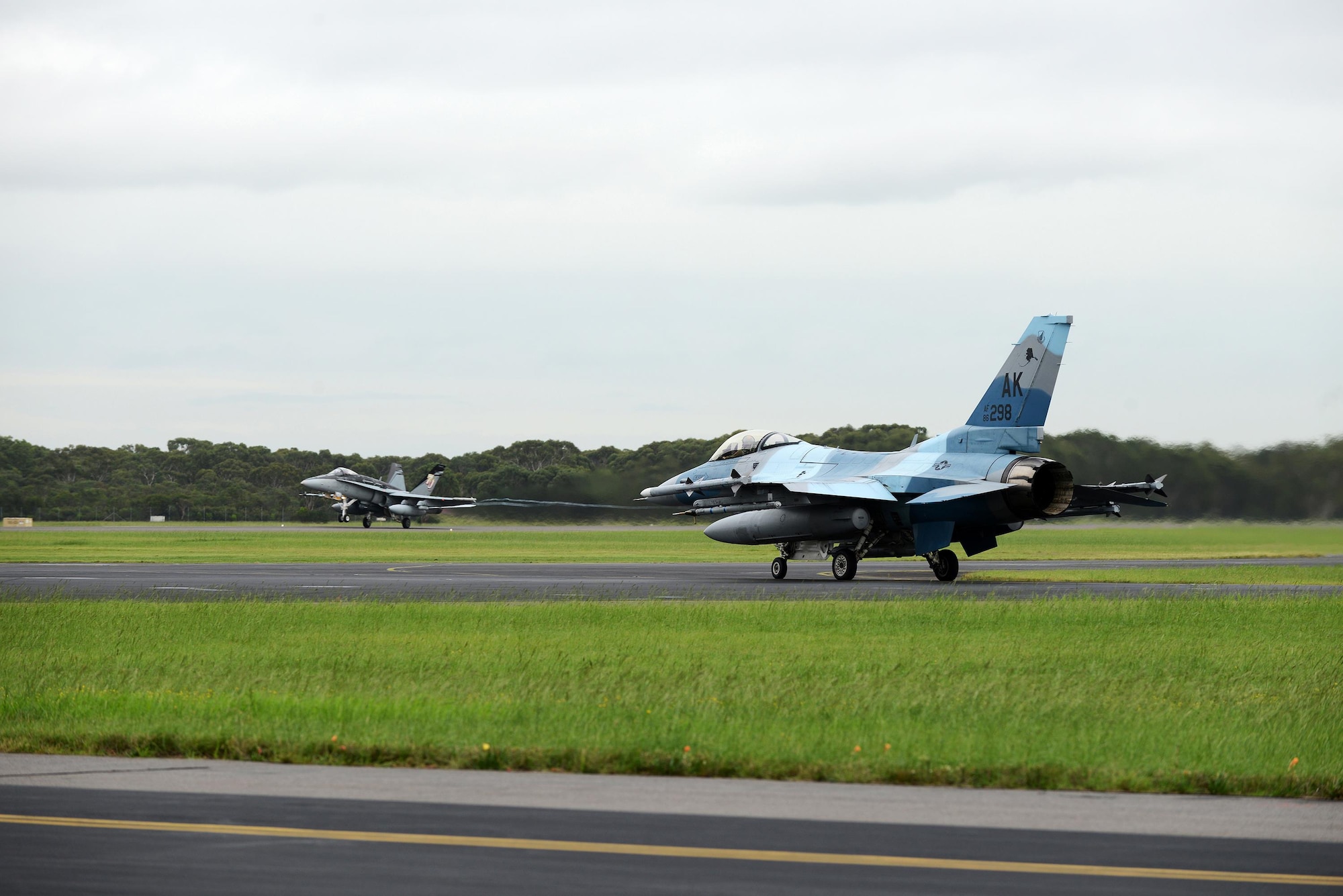 A U.S. Air Force F-16 Fighting Falcon taxis as a Royal Australian Air Force F-18A Hornet takes off at RAAF Williamtown, during Exercise Diamond Shield 2017 in New South Wales, Australia, March 23, 2017. The F-16 and the F-18 served as the primary platforms for providing ‘Red Air’ and ‘Blue Air’ forces, respectively. (U.S. Air Force photo by Tech. Sgt. Steven R. Doty)