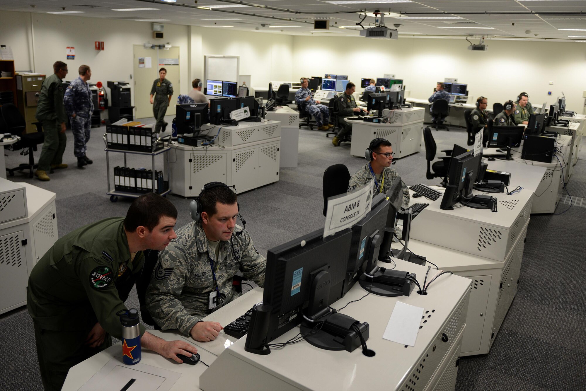 Royal Australian Air Force Flying Officer Paul Kowald, 3 Control and Reporting Unit air battle manager (bottom left), reviews exercise scenario data with U.S. Air Force Tech. Sgt. Wesley Miller, 18th Aggressor Squadron baron controller, in the Tactical Control Center, on RAAF Base Williamtown, New South Wales, Australia, March 23, 2017. Baron controllers are subject matter experts responsible for teaching joint and allied forces how to combat fighter tactics and capabilities of threat countries around the world both safely and effectively.(U.S. Air Force photo by Tech. Sgt. Steven R. Doty)