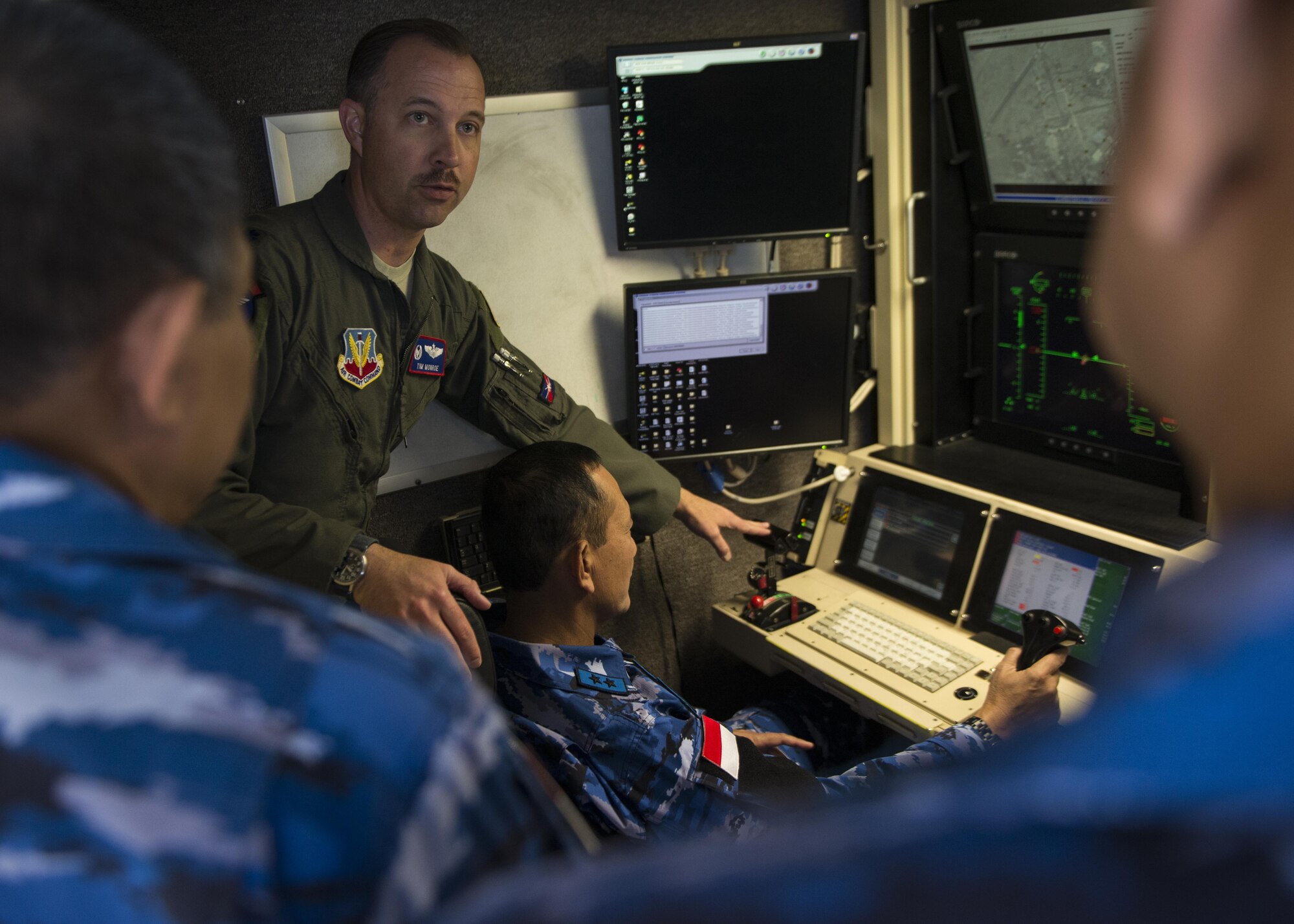 Lt. Col. Timothy Monroe, the 9th Attack Squadron commander, shows Maj. Gen. Dedy Permadi, an Indonesian Air Force officer, how to operate a remotely piloted aircraft, via a flight simulation, during a distinguished visitor tour at Holloman Air Force Base, N.M. on March 15, 2017. Members of the IDAF visited the MQ-9 Flight Training Unit and the 16th Training Squadron here to learn about RPA flight operations. (U.S. Air Force photo by Airman 1st Class Alexis P. Docherty)