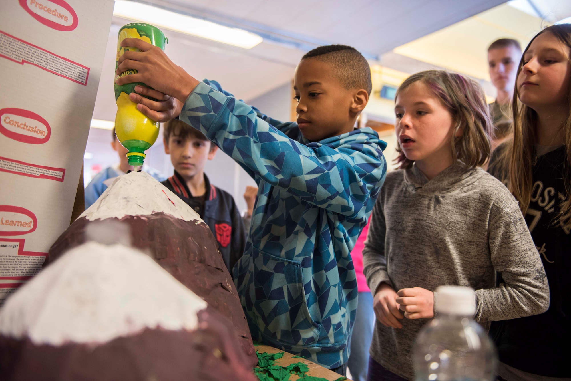 A student from Stephensen Elementary School pours lemon juice in his science fair volcano at Mountain Home Air Force Base, Idaho, March 23, 2017. The school hosts annual science fairs in order to supplement a science based curriculum for children in kindergarten through fourth grade. (U.S. Air Force photo by Senior Airman Connor J. Marth/Released)