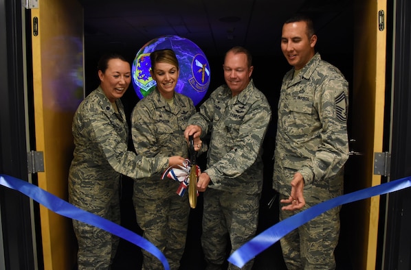 Lt. Col. Elizabeth Aptekar, 335th Training Squadron commander; Col. Michele Edmondson, 81st Training Wing commander; Col. Scott Solomon, 81st Training Group commander, and Chief Master Sgt. Randy Sabin, Air Education and Training Command weather functional manager, participate in a ribbon cutting ceremony to unveil a Science on a Sphere at the Weather Training Complex March 23, 2017, on Keesler Air Force Base, Miss. This latest training aid displays planetary data onto a suspended carbon-fiber sphere helping instructors enhance student’s understanding of the atmosphere. (U.S. Air Force photo by Kemberly Groue)