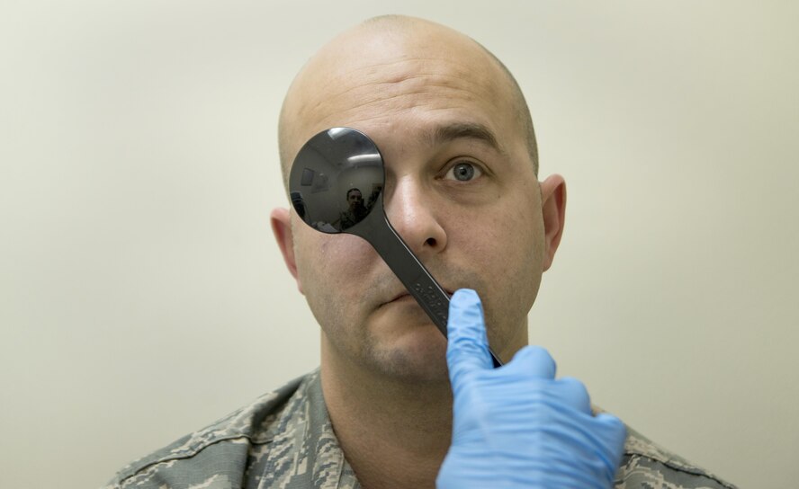U.S. Air Force Tech. Sgt. Christopher Hutchinson, a 35th Aerospace Medicine Squadron optometry technician, covers a patient’s eye during an ocular motility test at Misawa Air Base, Japan, March 10, 2017. Testing eye muscle movements is a preliminary part of a comprehensive eye examination. Eye care is a crucial factor in an Airmen’s overall combat-readiness. (U.S. Air Force photo by Staff Sgt. Melanie A. Hutto)