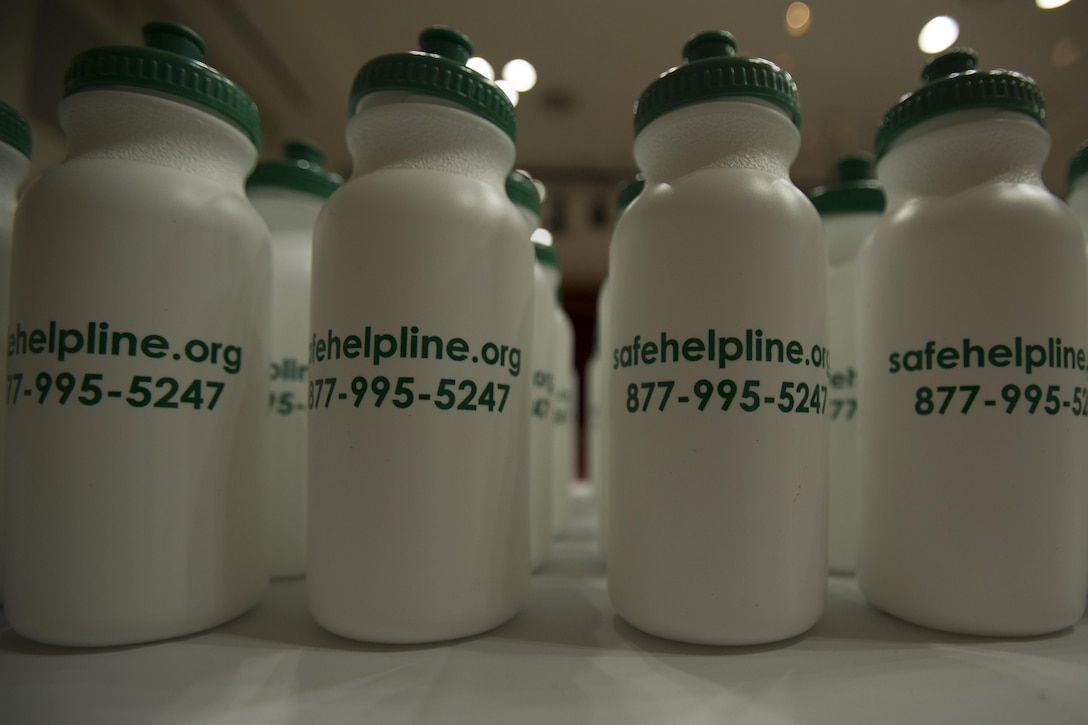 Water bottles with the Safe Helpline information sit on a table