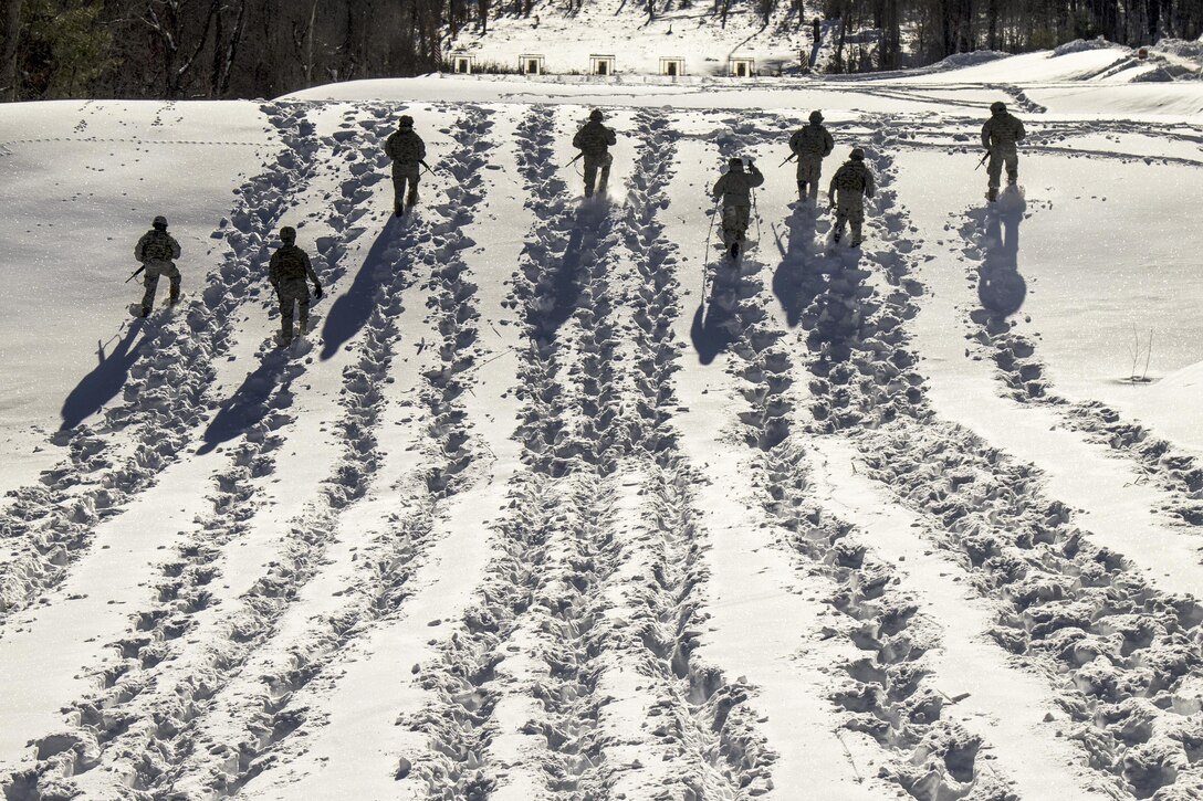 Soldiers advance through snow to their next firing position during a stress shoot as part of the Vermont Best Warrior Competition at Camp Ethan Allen Training Site, Jericho, Vt., March 18, 2017.  During the three-day event, elite soldiers take physical fitness tests and written exams, and perform warrior tasks relevant to the current environment.  Army National Guard Photo by 1st Lt. Benjamin Haulenbeek