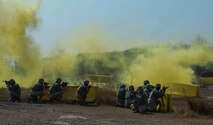 U.S. Air Force 8th Security Forces Squadron members take cover while yellow smoke signals an attack during a field training exercise at Kunsan Air Base, Republic of Korea, March 17, 2017. The training exercise is used to increase U.S. combat readiness and ultimately enhance the U.S. commitment to maintaining peace in the region. (U.S. Air Force photo by Senior Airman Colville McFee/Released)