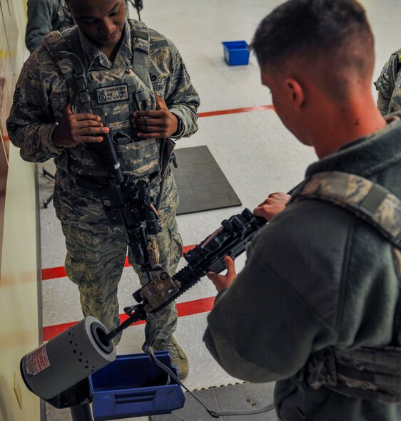 U.S. Air Force Staff Sgt. Jonathan Pate, 8th Security Forces Squadron member, left, inspects the M-4 assault rifle of Airman 1st Class Isaac Holm, 8th Security Forces Squadron member, during a field training exercise at Kunsan Air Base, Republic of Korea, March 17, 2017. The training exercise is used to increase U.S. combat readiness and ultimately enhance the U.S. commitment to maintaining peace in the region. (U.S. Air Force photo by Senior Airman Colville McFee/Released)