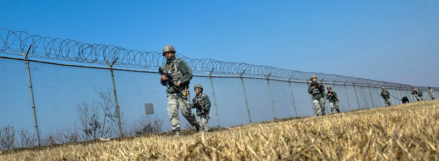 U.S. Air Force 8th Security Forces Squadron members, march in a tactical staggered formation while observing their surroundings during a field training exercise at Kunsan Air Base, Republic of Korea, March 17, 2017. U.S. Airmen work side by side to integrate air and ground operations more effectively in order to deter aggression in the region. (U.S. Air Force photo by Senior Airman Colville McFee/Released)