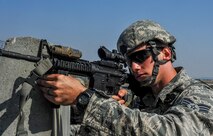 U.S. Air Force Senior Airman Brandon Weese, 8th Security Forces Squadron team leader, defends the base behind the cover of a concrete barrier with his M-4 assault rifle during a field training exercise at Kunsan Air Base, Republic of Korea, March 17, 2017. Opposing forces attack the security forces members to test their teamwork and communication skills under stressful situations. U.S. Airmen work side by side to integrate air and ground operations more effectively in order to deter aggression in the region. (U.S. Air Force photo by Senior Airman Colville McFee/Released)