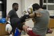 Staff Sgt. Dustin Payne, 374th Airlift Wing public affairs broadcast craftsman, performs a high kick while sparring with his trainer at a gym in the Hachioji ward of Tokyo, Japan, Mar. 14, 2017. Payne has been training with professional Japanese kickboxers for a year and a half. (U.S. Air Force photo by Senior Airman David C. Danford)