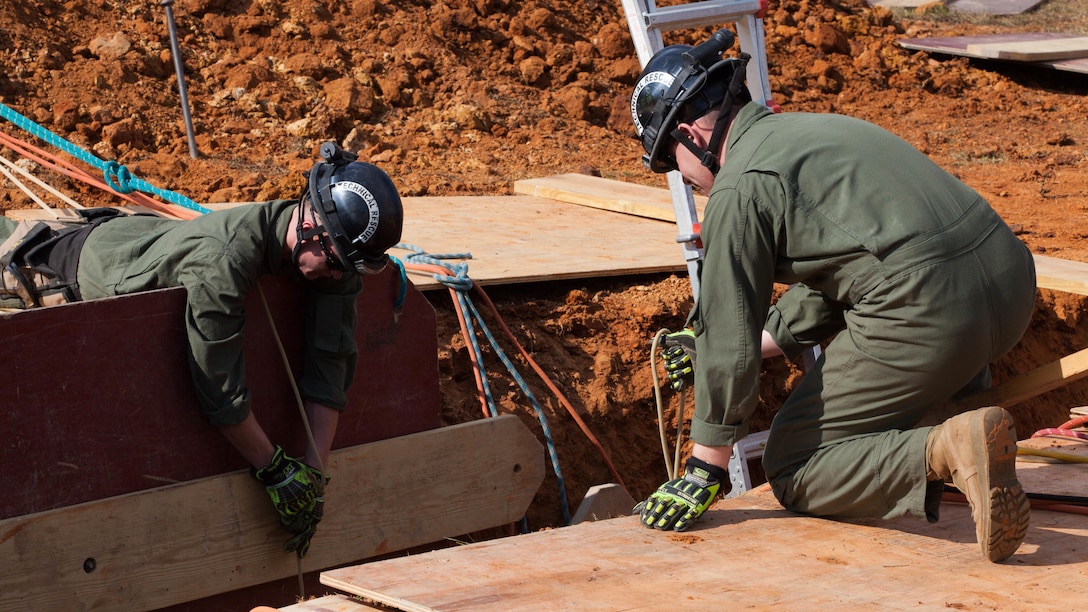 Cpl. Alexander Sutter, left, and Cpl. Vincent Leon, both Marines with Chemical Biological Incident Response Force, fix plywood into a 12-foot trench at Guardian Centers in Perry, Ga., March 20, 2017, during Exercise Scarlet Response 2017. The exercise, which goes from March 20 – 25, is the largest annual event for CBIRF, and it tests the unit’s capabilities to react and respond to threats and disasters such as nuclear detonations.