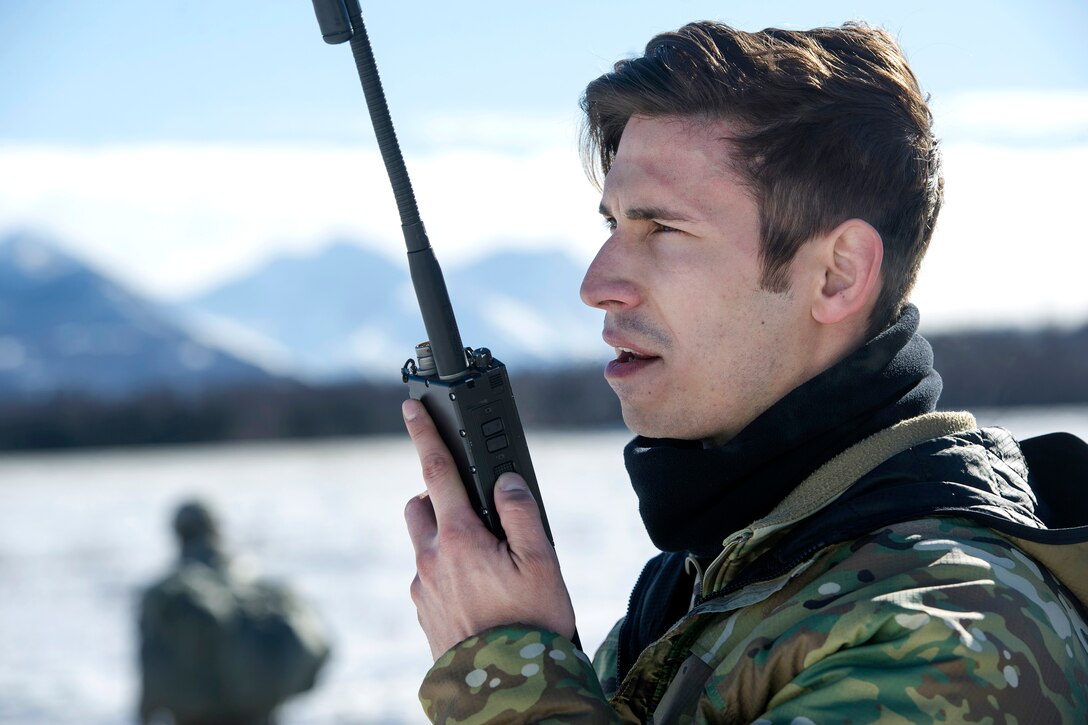 Air Force Senior Airman Carlos Gomez communicates with the pilots in a UH-60 Black Hawk helicopter during jump training at Joint Base Elmendorf-Richardson, Alaska, March 22, 2017. Gomez is a tactical air control party specialist assigned to the 3rd Air Support Operations Squadron. Air Force photo by Alejandro Pena 