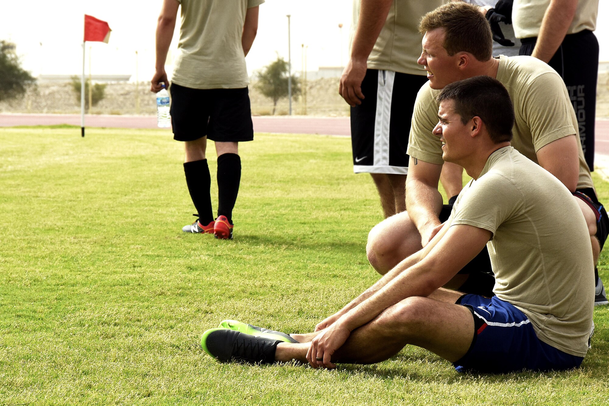 U.S. Air Force Airmen with the 379th Expeditionary Security Forces Squadron rest between halves during a soccer game with Qatar Emiri Air Force Security Forces members at Al Udeid Air Base, Qatar, March 23, 2017. The Airmen who participated in the game and those who went to support their team had the chance to interact with their host nation counterparts during the friendly match. (U.S. Air Force photo by Senior Airman Cynthia A. Innocenti)