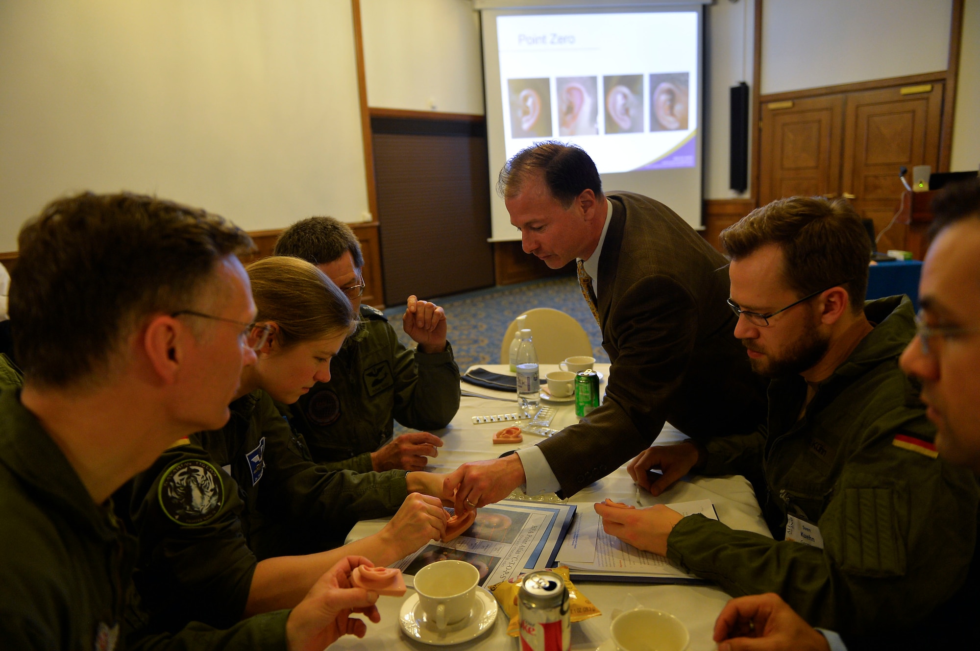 Retired Air Force Col. Thomas R. Piazza, M.D., Air Force Acupuncture Program director, assists attendees from NATO countries during a battlefield acupuncture class on Ramstein Air Base, Germany, March 21, 2017. Military aerospace medicine personnel from the U.S. and allied nations converged on Ramstein for an annual summit to discuss developments in the aeromedical field. (U.S. Air Force photo by Airman 1st Class Joshua Magbanua)