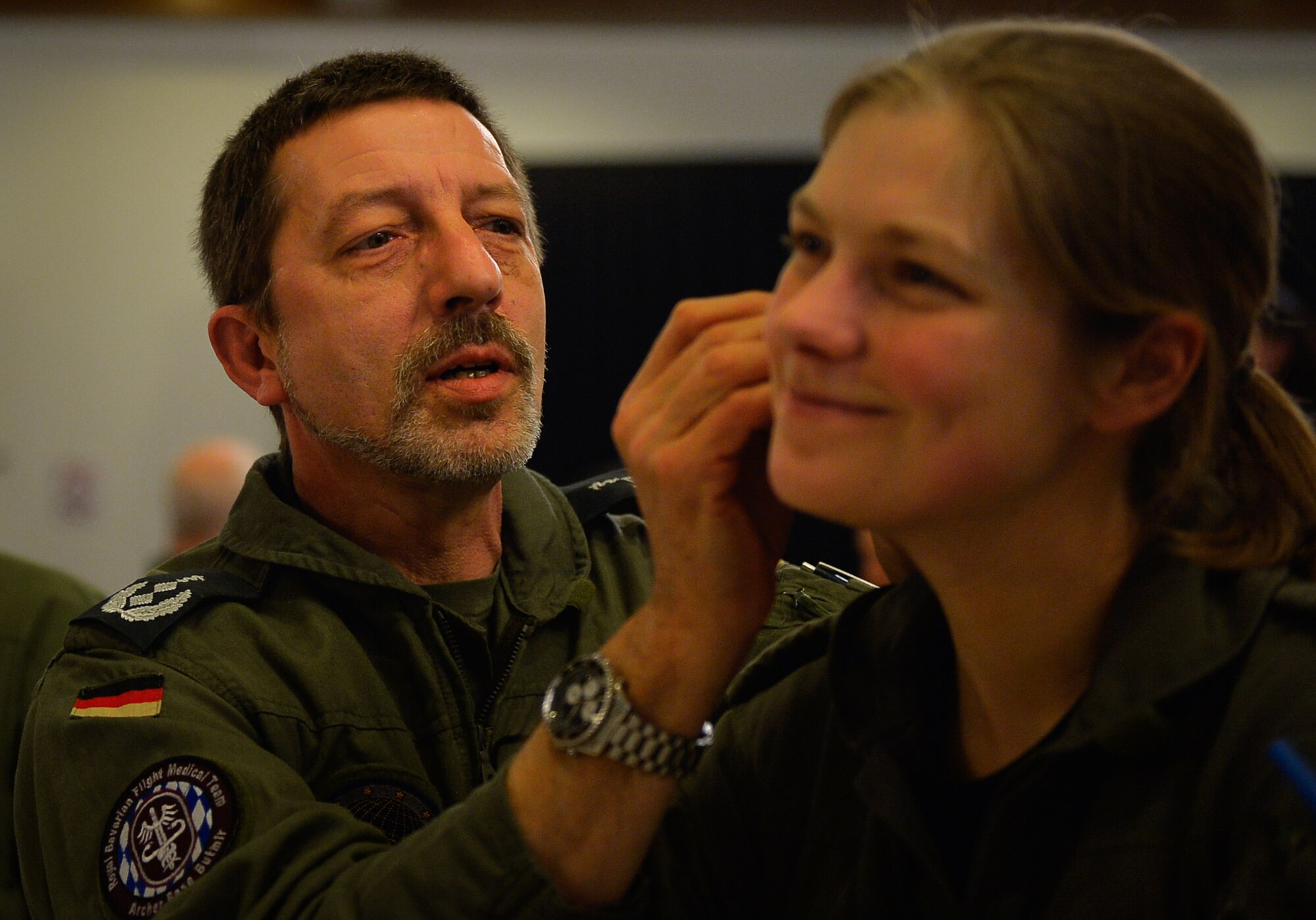 Lt. Col. Michael Kiefer, a German Air Force flight surgeon, gives battlefield acupuncture to Maj. Tanja Drews, also a German Air Force flight surgeon, during an aerospace medicine conference on Ramstein Air Base, Germany, March 21, 2017. Although battlefield acupuncture originated as a method to give quick pain relief to troops in battle, the practice made its way into non-combat environments. (U.S. Air Force photo by Airman 1st Class Joshua Magbanua)