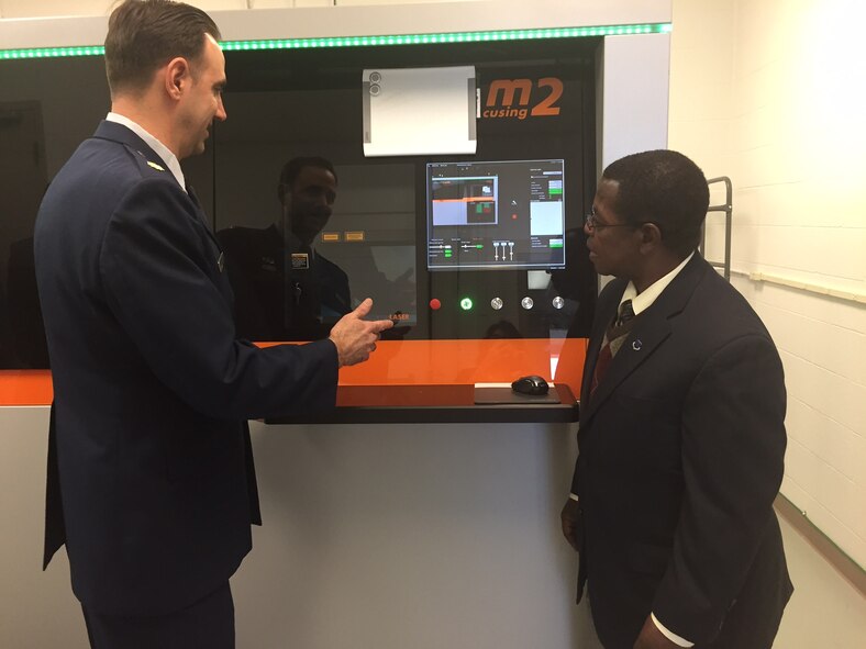 Major Ryan O’Hara, assistant professor, Graduate School of Engineering and Management, Air Force Institute of Technology, describes how a new 3D metal additive manufacturing system works to Dr. Adedeji Badiru, dean of the school. (Skywrighter photo/Amy Rollins)