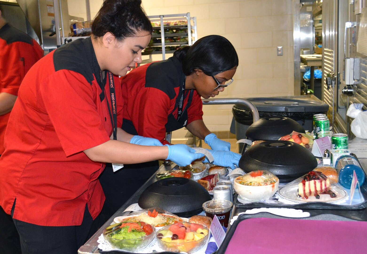 Quashonda Cain and Janaine Briggs fix Proud Parent meal trays at Brooke Army Medical Center at Joint Base San Antonio-Fort Sam Houston March 14. Each tray features a lavender flowered place mat, lavender napkin and a card for the new parents. The food is delivered fresh and hot from the kitchen and garnished to make an appetizing display.