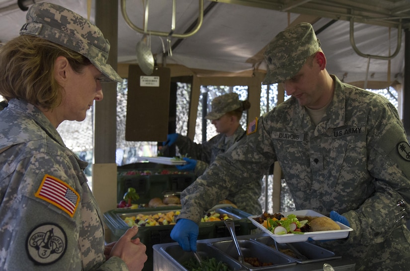 Chief Warrant Officer 5 Pamela Null (left), the U.S. Army Reserve Command Food Advisor, receives the first plate during lunch service from the culinary team of the 391st Military Police Battalion as part of the 49th Philip A. Connelly Award for Excellence in Army Food Service competition at Camp Blanding, Florida, March 17, 2017. Null was one of three evaluators reviewing the 391st MP Bn.'s food service operations as part of the competition. The 391st MP BN, one of four Army-wide finalists, selected Camp Blanding, Florida, as their location for the final level of testing in the competition. (U.S. Army Reserve photo by Sgt. 1st Class Carlos Lazo)
