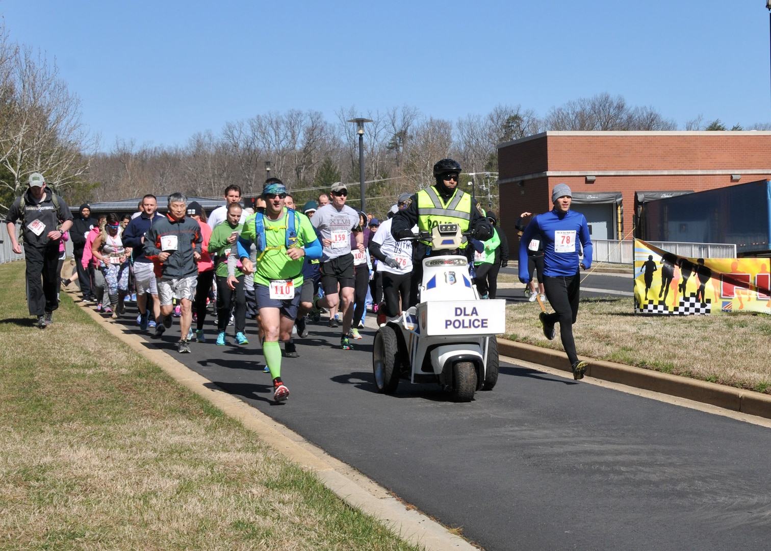 Runners and walkers depart the starting line on a brisk March day.