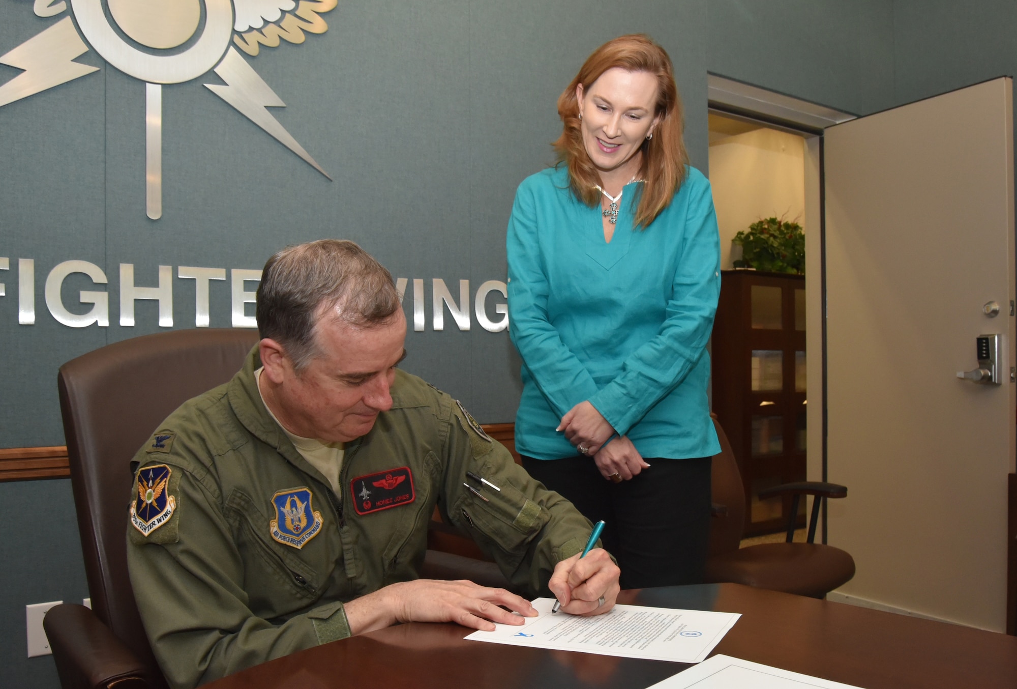 NAVAL AIR STATION FORT WORTH JOINT RESERVE BASE, Texas -- Col. Gregory Jones, 301st Fighter Wing commander, signs the Sexual Assault Awareness and Prevention proclamation with Ms. Laura Loftin, the Sexual Assault Response Coordinator for the wing, Wed. March 22, 2017. The proclamation serves as a reminder for Airmen to speak out against acts of sexual assault as a means to increase awareness and prevention. (U.S. Air Force photo by Tech. Sgt. Melissa Harvey)
