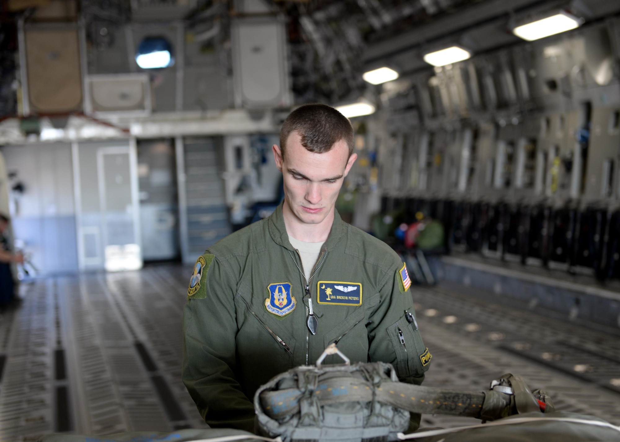 U.S. Air Force Senior Airman Brendin Peters, 317th Airlift Squadron loadmaster, secures a cargo training pallet on a U.S. Air Force C-17 Globemaster III cargo aircraft, March 17, 2017, Altus Air Force Base, Oklahoma. Brendin Peters participated in a refueling training mission where his crew’s C-17 was refueled by a U.S. Air Force KC-135 Stratotanker refueling aircraft piloted by his father U.S. Air Force Col. Craig Peters, 940th Air Refueling Wing commander. (U.S. Air Force photo by Airman 1st Class Jackson N. Haddon/Released)