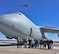 Regional airport managers from western Massachusetts and New England take a break for a photo in front of a C-5M Super Galaxy at Westover, March 23, 2017, while a C-5A Galaxy flies overhead. The managers toured the Dover Air Force Base, Del.-based C-5M and were briefed on the 439th Airlift Wing’s eventual modernization to the M-models, beginning later into 2017. Westover Air Reserve Base is a joint-use airfield, with the Air Force sharing its runways with the adjacent Westover Metropolitan Airport. (U.S. Air Force photo/Master Sgt. Andrew Biscoe)