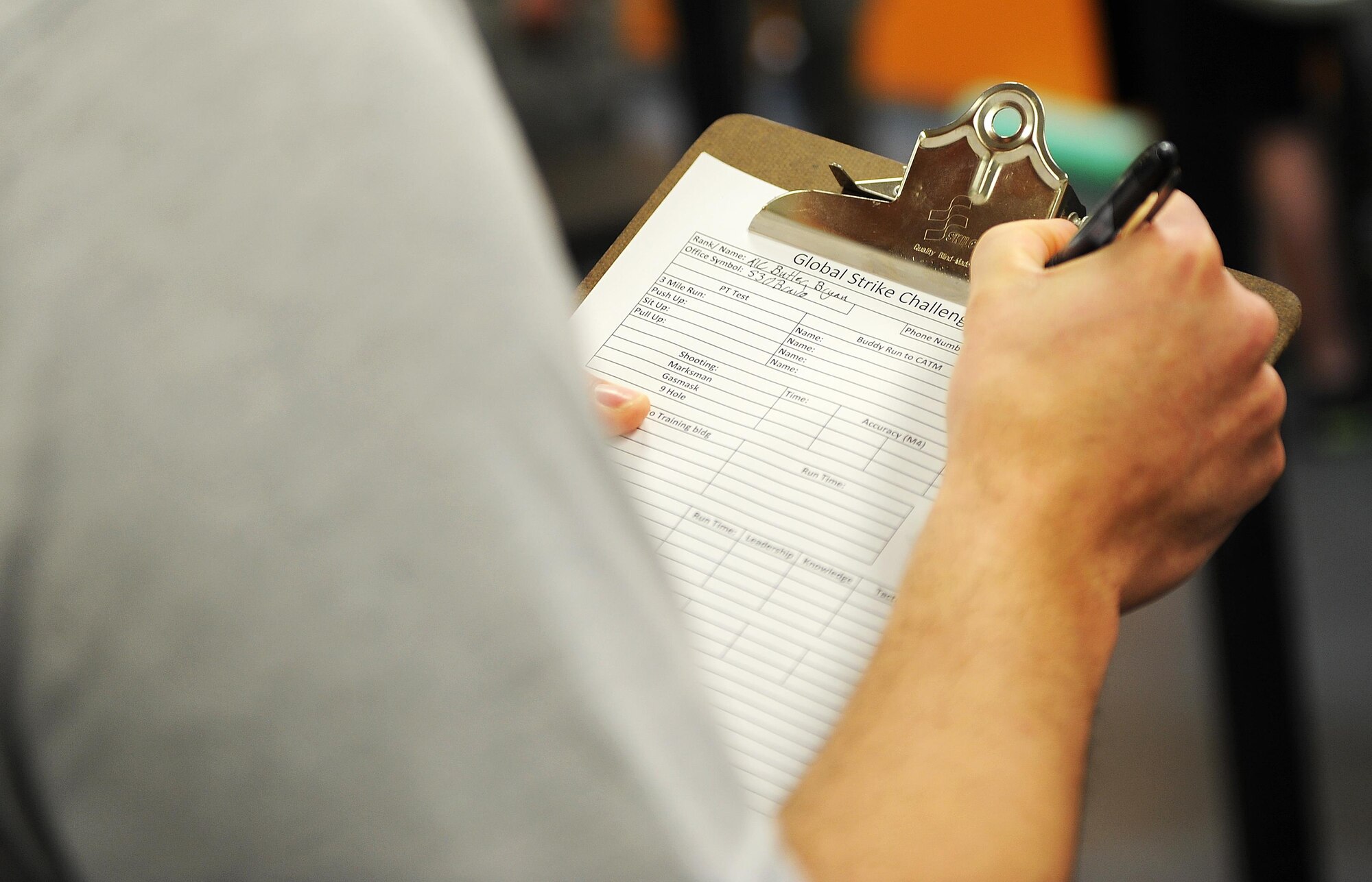 Airman 1st Class Bryan Butler, 5th Security Forces Squadron defender, fills out a form for Global Strike Challenge tryouts at Minot Air Force Base, N.D., March 16, 2017. The tryouts pushed the defenders to their physical limits with a ruck in full gear, push-ups, pull-ups, sit-ups, buddy runs, room clearing and weapons firing.  (U.S. Air Force photo/Senior Airman Kristoffer Kaubisch)
