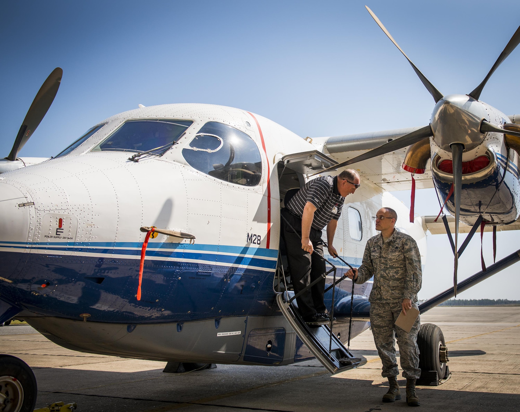 Dale Rice exits a C-145A Skytruck while talking with Maj. Terrell Eikner, the 919th Aircraft Maintenance Squadron commander, during the Crestview Military Affairs Committee’s tour of Duke Field, Fla., March 23.  (U.S. Air Force photo/Tech. Sgt. Samuel King Jr.)