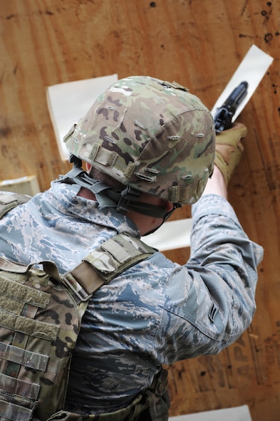 Airman 1st Class Christopher Brooks, 5th Security Forces Squadron, shoots a M9 pistol at a target for Global Strike Challenge tryouts at Minot Air Force Base, N.D., March 16, 2017. The 9 hole board teaches defenders how to shoot in different positions. (U.S. Air Force photo/Senior Airman Kristoffer Kaubisch)