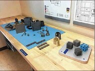 Additive manufacturing processes are known for their ability to fabricate parts with complex geometries. Lattice structures, like the samples shown, leverage this ability to create parts with high strength-to-weight ratio and other desirable structural qualities. The Graduate School of Engineering and Management at the Air Force Institute of Technology, Wright-Patterson Air Force Base, unveiled its new 3D metal additive manufacturing system March 16. (Skywrighter photo/Amy Rollins)