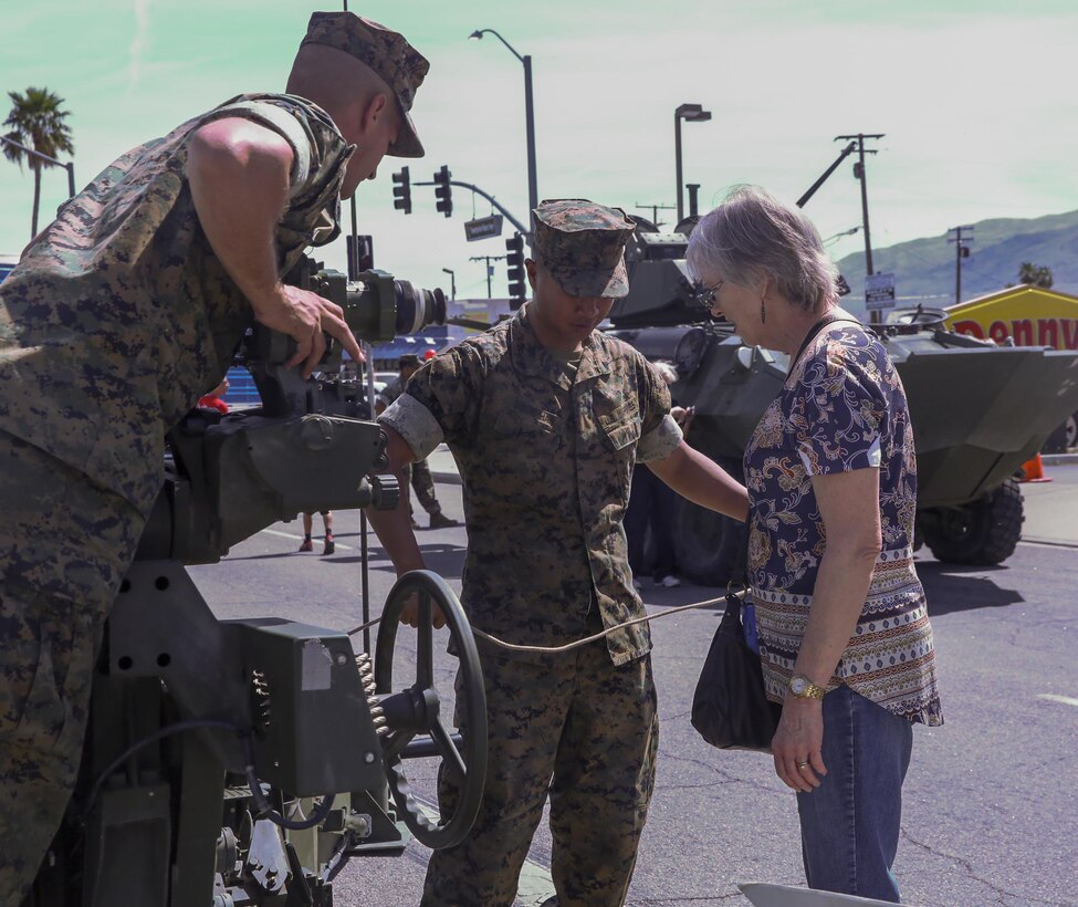 Marines with 3rd Battalion, 11th Marine Regiment, explain the mechanics of a Light Armored Vehicle to a Twentynine Palms resident during the 17th annual Car Show & Street Fair in Twentynine Palms, Calif., March 18, 2017. The Twentynine Palms Chamber of Commerce hosted the event to bring the community together. (U.S. Marine Corps photo by Lance Cpl. Natalia Cuevas)