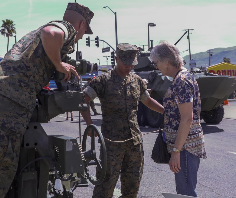 Marines with 3rd Battalion, 11th Marine Regiment, explain the mechanics of a Light Armored Vehicle to a Twentynine Palms resident during the 17th annual Car Show & Street Fair in Twentynine Palms, Calif., March 18, 2017. The Twentynine Palms Chamber of Commerce hosted the event to bring the community together. (U.S. Marine Corps photo by Lance Cpl. Natalia Cuevas)