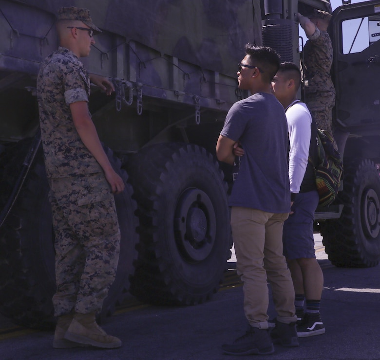 A Marine with 3rd Light Armored Reconnaissance Battalion, speaks with community members during the 17th annual Car Show & Street Fair in Twentynine Palms, Calif., March 18, 2017. The Twentynine Palms Chamber of Commerce hosted the event to bring the community together. (U.S. Marine Corps photo by Lance Cpl. Natalia Cuevas)