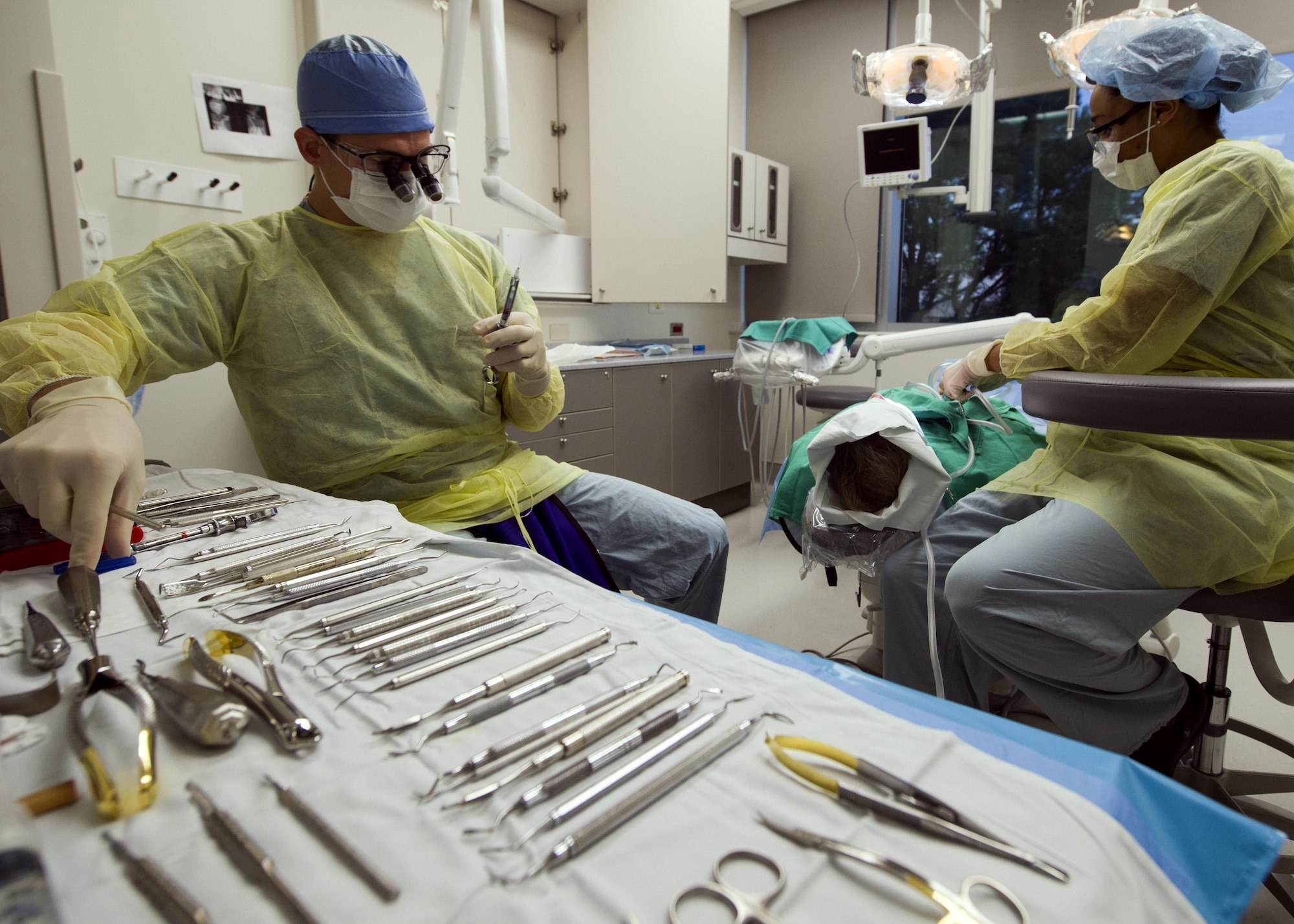 Senior Airman Vanessa Powell-Davis, right, 59th Dental Training Squadron periodontics technician, prepares a patient for periodontal surgery performed by Capt. Andrew Verrett, a 59th DTS periodontics resident, at the Air Force Postgraduate Dental School, Joint Base San Antonio-Lackland, Texas. The wing’s postgraduate medical education function provides a wide array of training programs ranging from general surgery to emergency medical services administration. (U.S. Air Force photo/Staff Sgt. Kevin Iinuma)