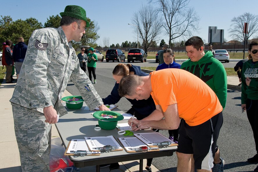 Tech. Sgt. Jeremy Simon, 436th Force Support Squadron fitness center specialist, ensures Team Dover participants sign in for the St. Patrick's Day "Four Leaf Clover Warrior Run," March 17, 2017, on Dover Air Force Base, Del. One hundred eighty-five runners took part in the five kilometer race that started and ended on the running trail near The Landings. Tech. Sgt Ross Krotzer, 373rd Training Squadron, Detachment 3, won the race with a time of 19 minutes and 50 seconds.  Senior Airman Tamara Gensel, 436th Force Support Squadron, was the fastest female with a time of 23 minutes and 33 seconds. (U.S. Air Force photo by Roland Balik)