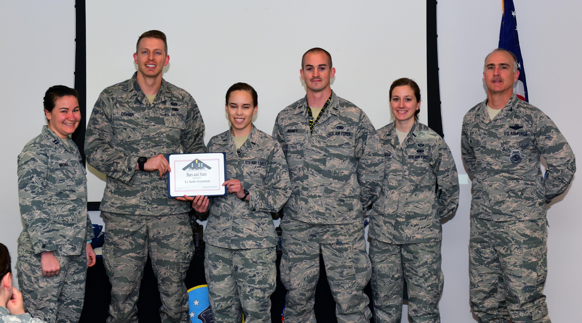 U.S. Air Force 2nd Lt. Seth Gammon, second from left, an intel analyst assigned to the 509th Operations Support Squadron, receives a Whiteman Company Grade Officer Council (CGOC) Bars and Stars award from members of the CGOC and Col. Mark Ely, far right, the 509th Bomb Wing vice commander, at Whiteman Air Force Base, Mo., March 13, 2017. Gammon implemented an internal briefing program within the intelligence flight to inform Airmen of enemy threats and to improve the briefing skills of the intelligence personnel. He also manages the fitness program for his squadron where he facilitated the execution of 27 quarterly mock assessment tests to improve passing scores and rates. (U.S. Air Force photo by Airman 1st Class Jazmin Smith)