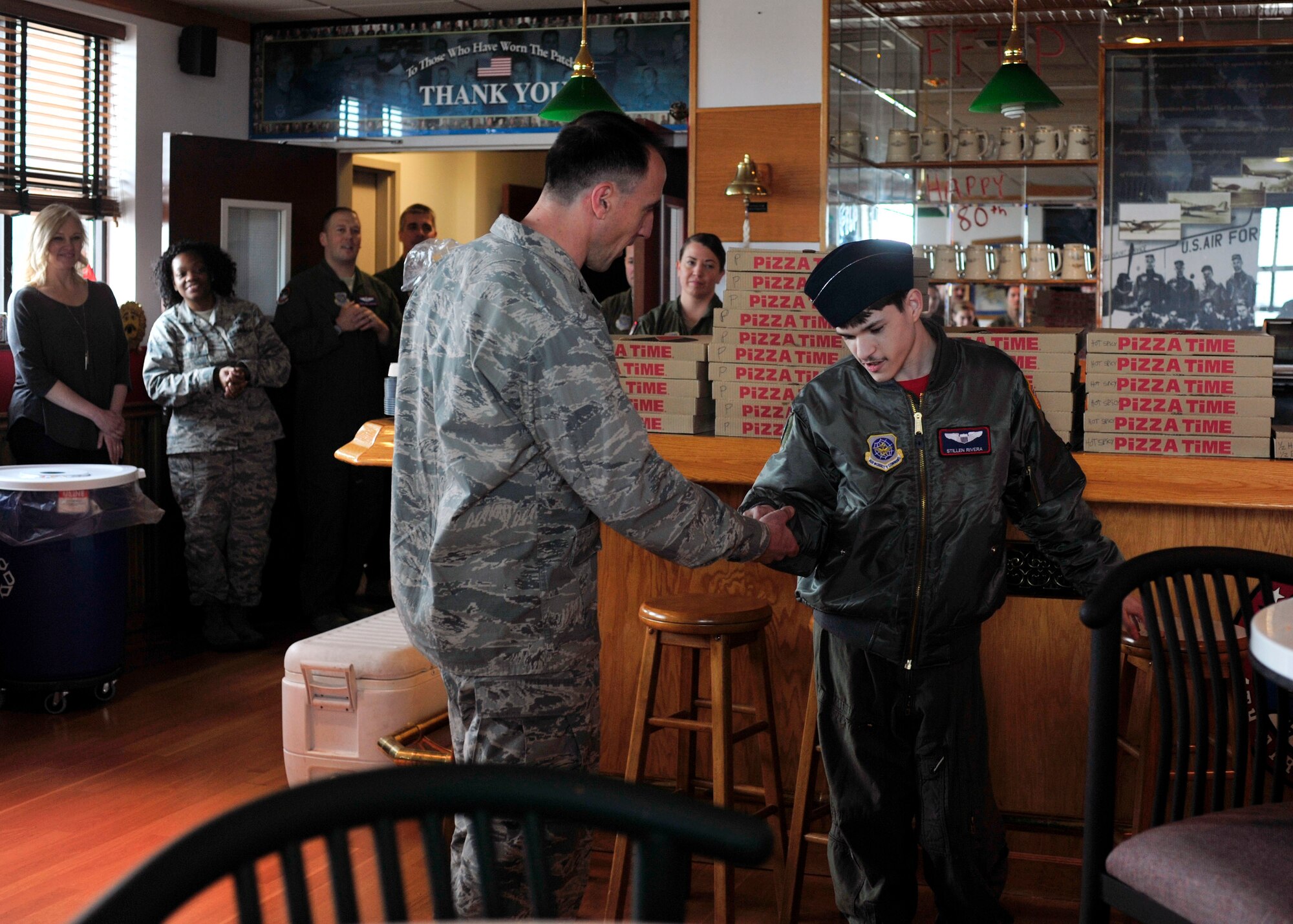 Col. Leonard Kosinski (left), 62nd Airlift Wing commander, coins Stillen Rivera, Team McChord’s newest “Pilot for a Day” participant, during a pizza party at the 4th Airlift Squadron, March 23, 2017 at Joint Base Lewis-McChord, Wash. The “Pilot for a Day” program, which has been hosted by Team McChord for several years, provides youth with a limiting disability the opportunity to live out their life-long dreams of aviation and share those memorable experiences with their family by their side. (U.S. Air Force photo/Staff Sgt. Whitney Amstutz)