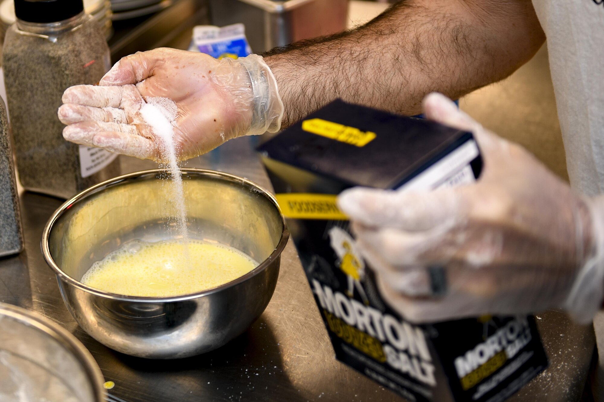 Mr. Derrick Harris, 23d Force Support Squadron Casualty Assistance Representative and
Survivor Benefit Plan counselor, adds salt to his mixture during the first Iron Chef Competition held at the Georgia Pines Dinning Facility ,March 23, 2017, at Moody Air Force Base, Ga. Four teams were given an hour to prepare their meals for the judges. The 23d Force Support Squadron plans to hold at least one Iron Chef Competition per year. (U.S. Air Force photo by Airman 1st Class Daniel Snider)
